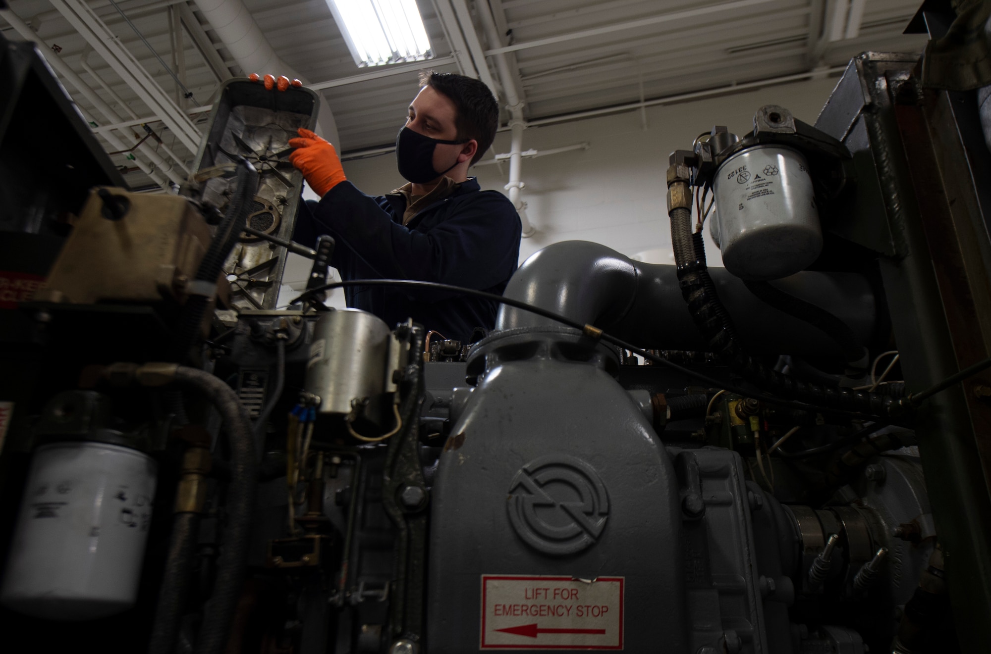 U.S. Air Force Airman 1st Class Korey Klausing, 62nd Maintenance Squadron Aerospace Ground Equipment Flight apprentice, inspects the engine air breather on a power generator at Joint Base Lewis-McChord, Washington, April 7, 2021. Klausing is performing an annual inspection on the generator and is looking for any cracks or damages on the unit. (U.S. Air Force photo by Senior Airman Tryphena Mayhugh)