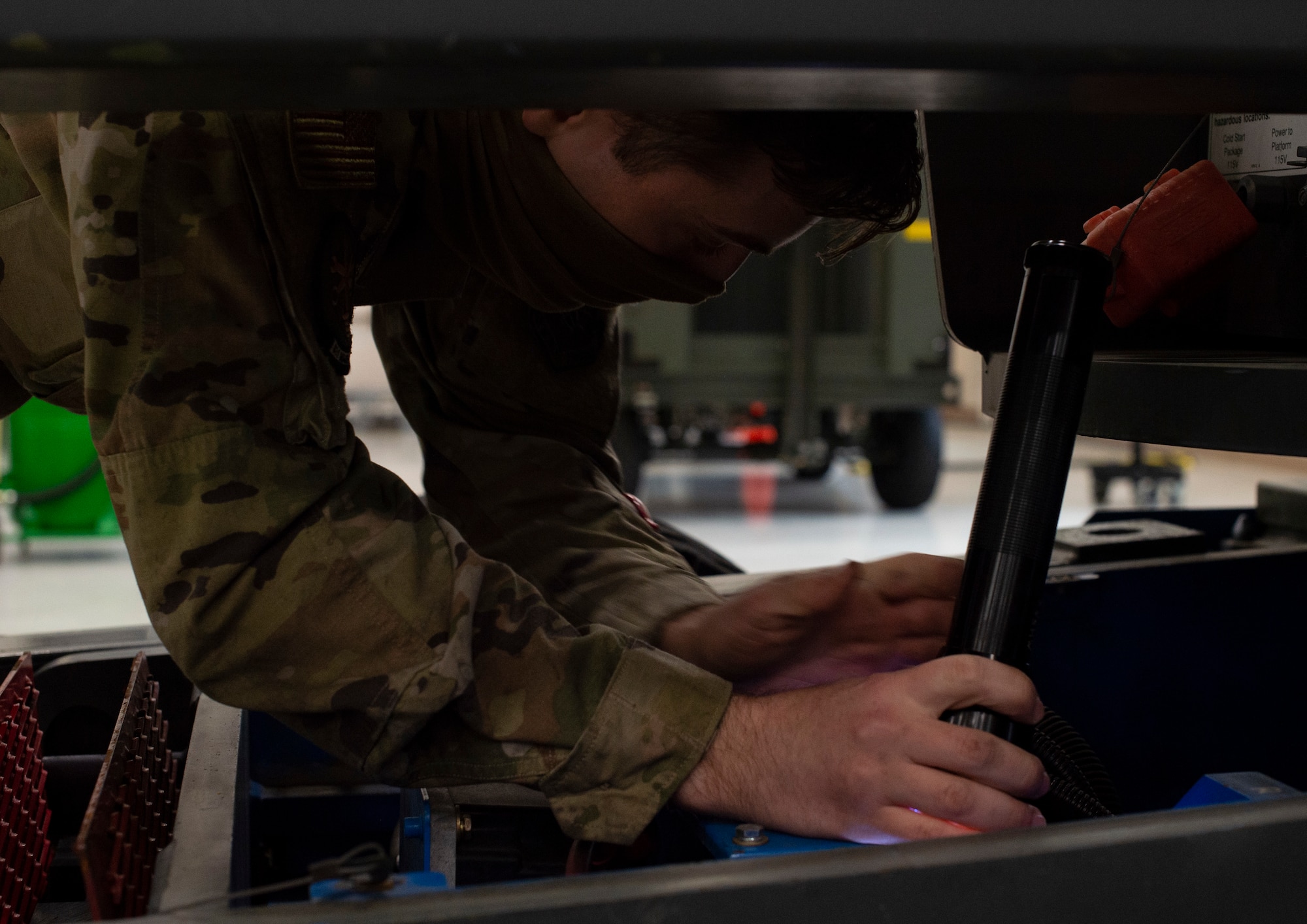U.S. Air Force Senior Airman Shawn Welch, 62nd Maintenance Squadron Aerospace Ground Equipment Flight, inspects the engine compartment of a man lift vehicle at Joint Base Lewis-McChord, Washington, April 7, 2021. The 62nd MXS AGE flight oversees all the equipment used to inspect, fix and maintain aircraft at McChord Field. (U.S. Air Force photo by Senior Airman Tryphena Mayhugh)
