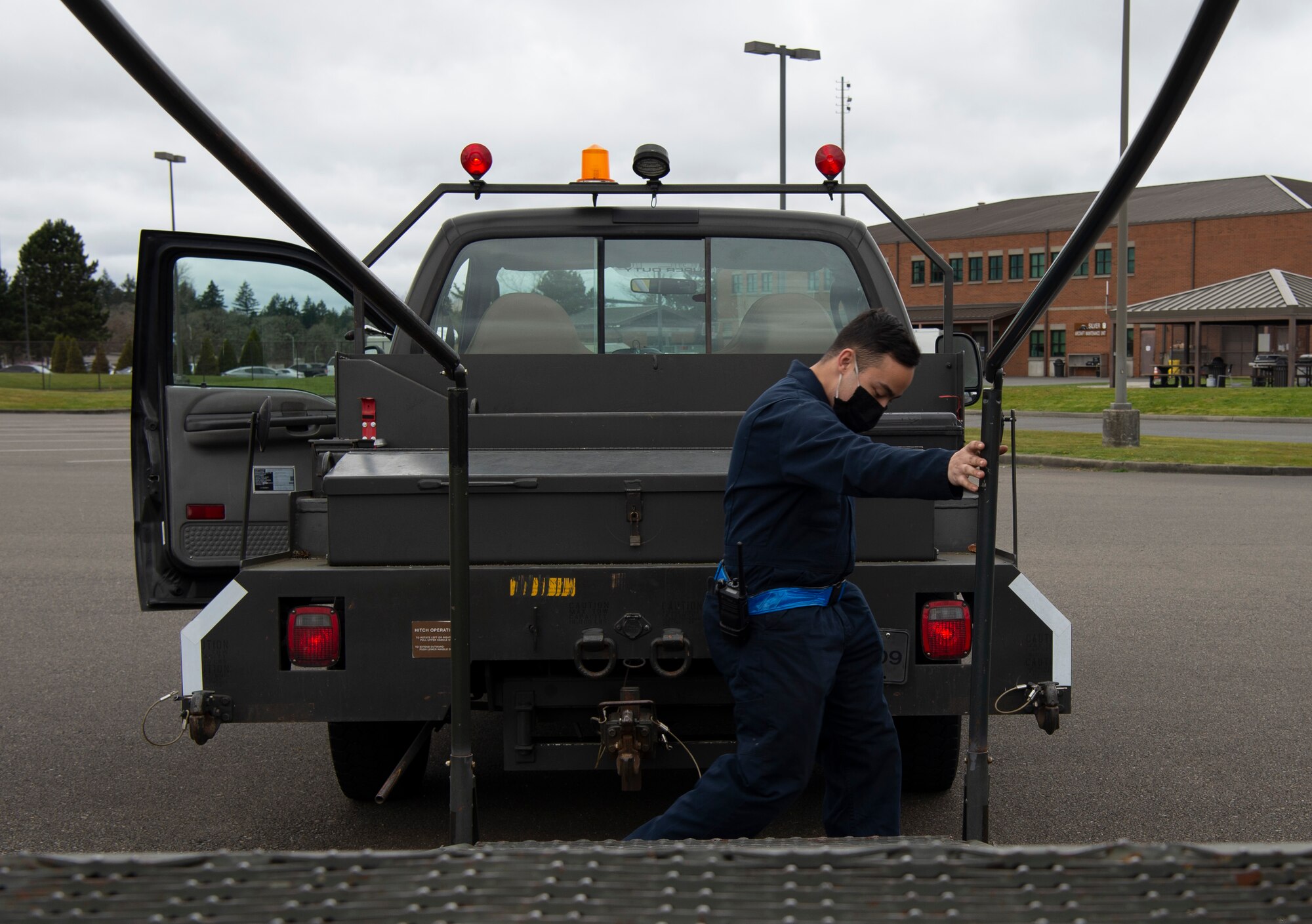 U.S. Air Force Airman 1st Class Sean Gilbert, 62nd Maintenance Squadron Aerospace Ground Equipment Flight apprentice, removes the brakes on a stand to hook it to his vehicle at Joint Base Lewis-McChord, Washington, April 7, 2021. Gilbert delivers equipment to the flightline to be used in the inspection and repair of C-17 Globemaster IIIs at McChord Field. (U.S. Air Force photo by Senior Airman Tryphena Mayhugh)