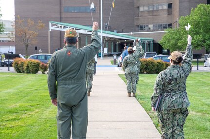 Norfolk Naval Shipyard (NNSY) team members hold white flags with hand written messages of support in the air marking a moment of silence during the shipyard’s Sexual Assault Awareness and Prevention Month (SAAPM) kickoff event April 9.
