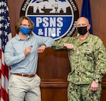 Capt. Jip Mosman, commander, Puget Sound Naval Shipyard & Intermediate Maintenance Facility, presents Mike Tracy, process management branch manager, Code 220, Resources, Training & Processes, with a Bravo Zulu sticker April 13, 2021, for co-leading a team with Bryson Delima, 2380.1RW Radioactive Waste branch head, that codified a sustainable engineering execution system, which was shared with all four U.S. Navy shipyards. Their combined efforts improved the turnaround time for Deficiency Log resolution from 2.4 days to less than one day by addressing visibility and behaviors at all levels of the command.
