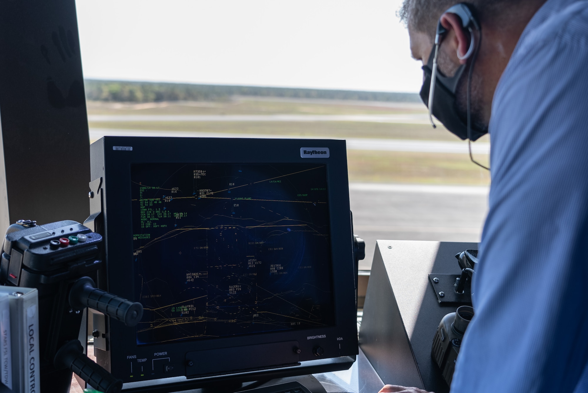 Civilian man observes screen displaying flight patterns.