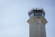 Control tower juxtaposed against blue sky.