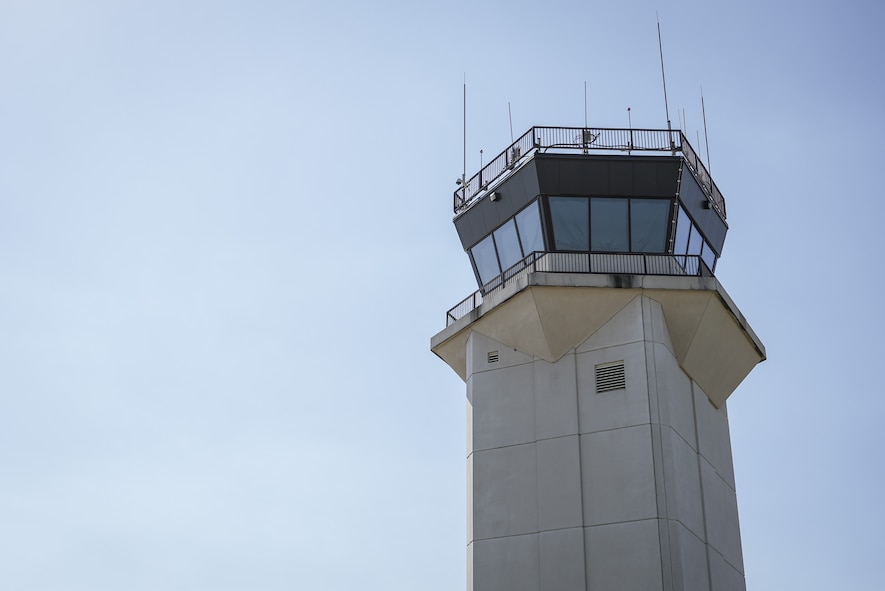 Control tower juxtaposed against blue sky.
