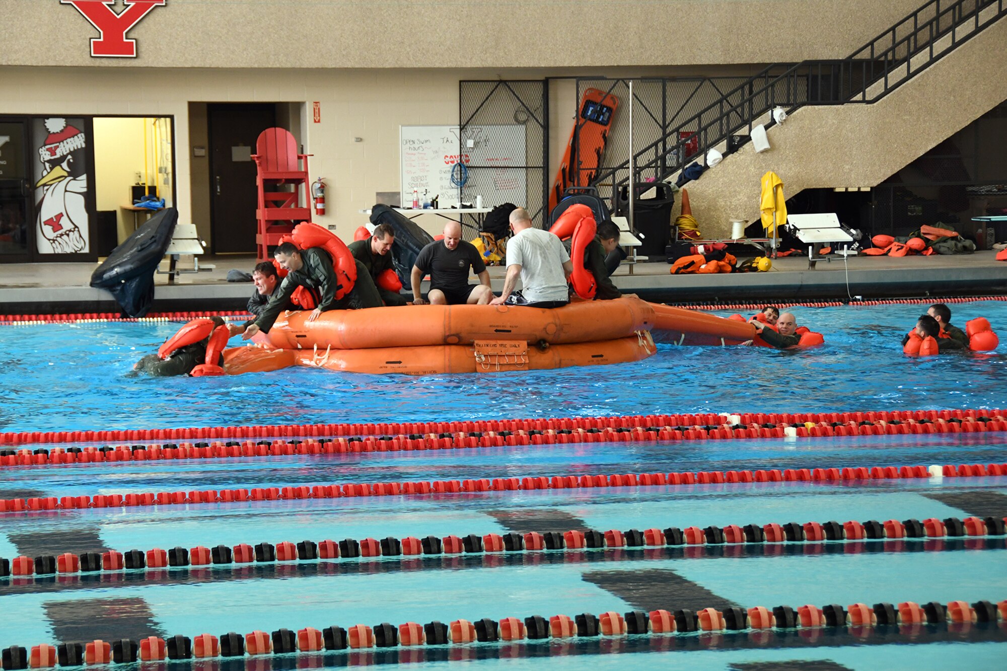 A group of Reserve Citizen Airmen assigned to the squadrons of the 910th Operations Group based at nearby Youngstown Air Reserve Station, help their fellow Airmen aboard a 20-person life raft during an aircrew water survival refresher training event at Youngstown State University’s Beeghly Natatorium Olympic Swimming Pool, April 11, 2021.