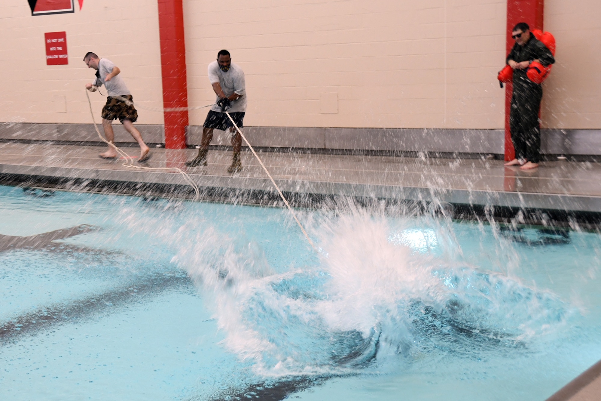 Air Force Reserve Senior Airman Matt Weems and Tech. Sgt. Eric Ruth, both Aircrew Flight Equipment Specialists based at nearby Youngstown Air Reserve Station, use a rope to pull Lt. Col. Frank Galati, 757th Airlift Squadron Director of Operations, through the water as part of a water landing parachute harness drag and release exercise during an aircrew water survival refresher training event at Youngstown State University’s Beeghly Natatorium Olympic Swimming Pool, April 11, 2021. Weems and Ruth were members of a 12-person team who conducted the training for a group of 34 Reserve Citizen Airmen assigned to the squadrons of the 910th Operations Group, which is a tri-annual requirement for all aircrew members. The training was broken into several blocks including aircrew familiarization of AFE water survival accessories aboard the 910th’s C-130H Hercules tactical cargo aircraft; 20-person and single-person life raft operations; swimming techniques; a water landing parachute harness drag and release as well as water landing parachute disentangling techniques.