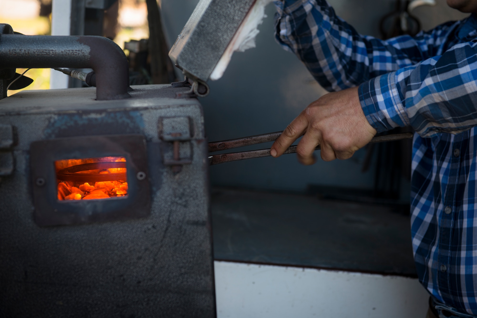Chris Hume, an independent farrier on the central coast of California, heats a horseshoe until it's red-hot to start the process of re-shodding a horse. The military horses get re-shodded every six weeks. (U.S. Air Force photo/Staff Sgt. Andrew Lee)