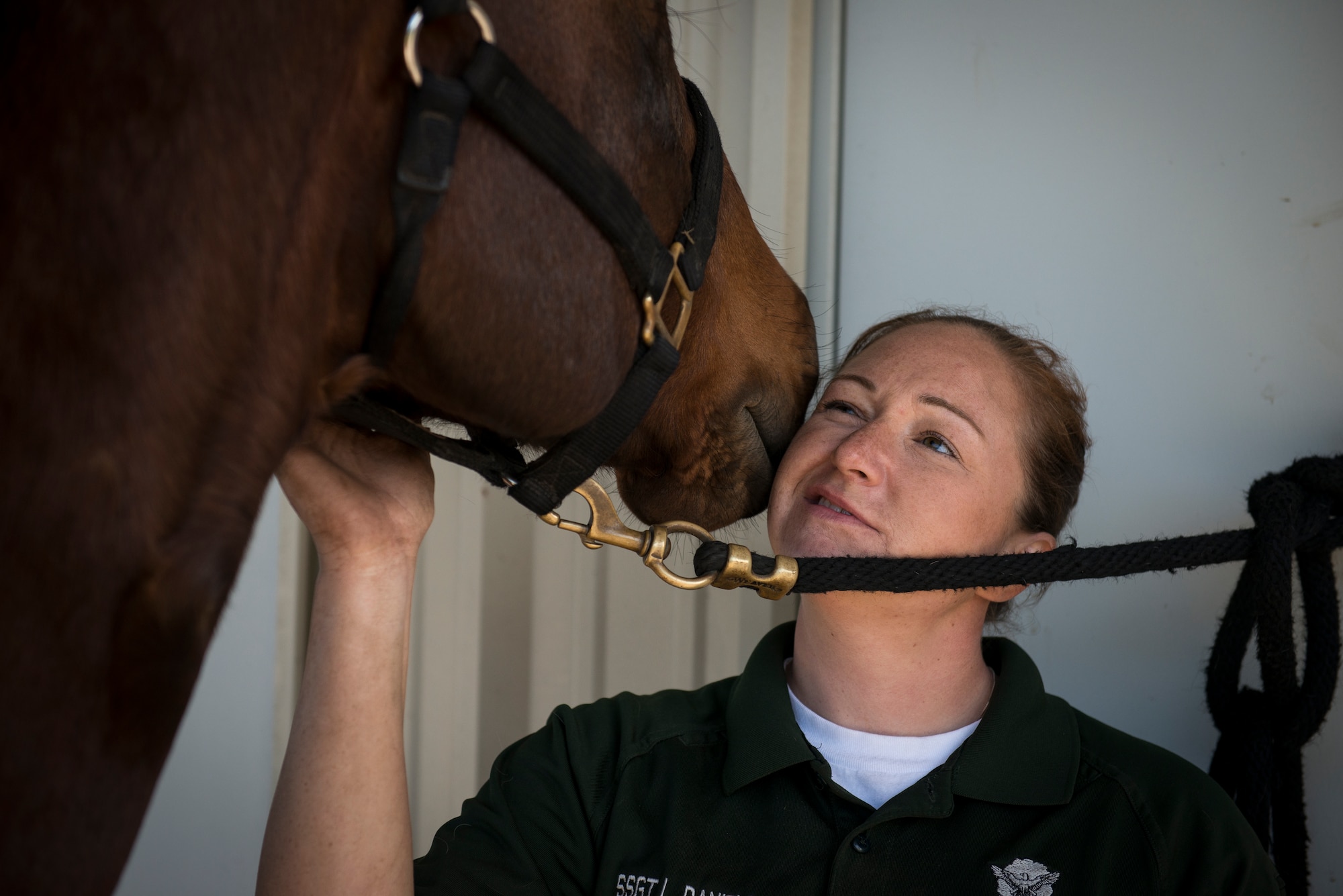 Reserve Staff Sgt. Lauren Daniels receives an unexpected kiss from Trooper, one of four military horses in the Vandenberg Air Force Base, California mounted patrol. (U.S. Air Force photo/Staff Sgt. Andrew Lee)