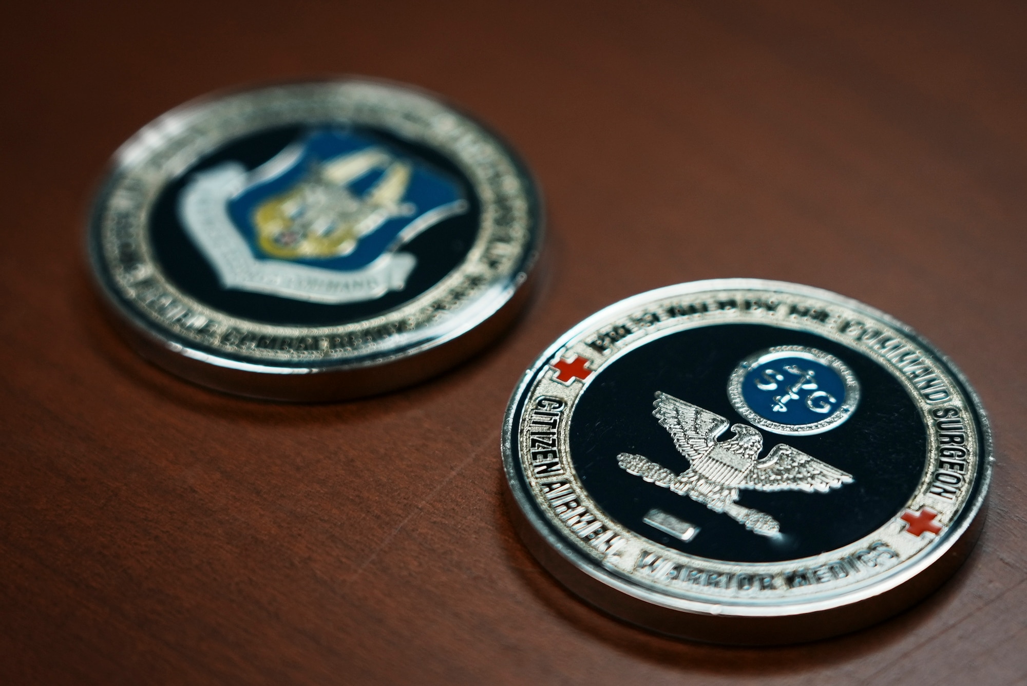 Coin with Air Force Reserve Command logo and eagle sit on top of desk.