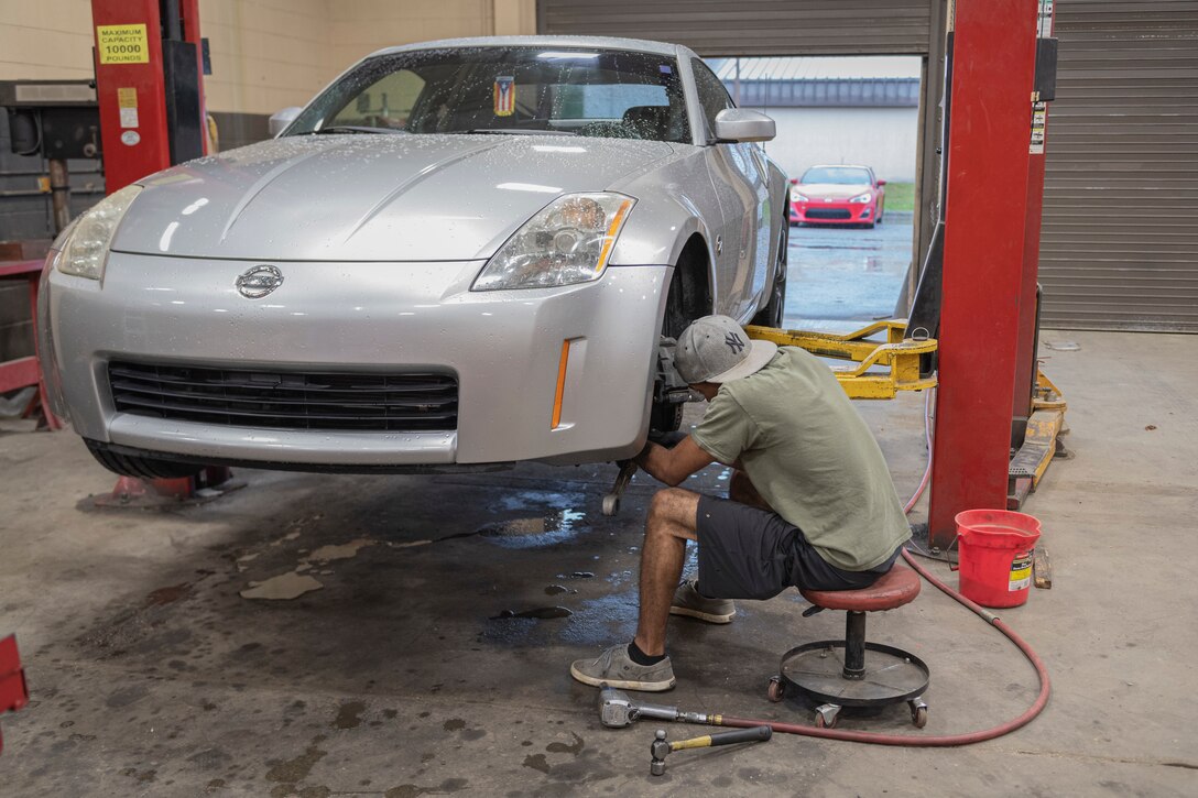 Photo of an Airman repairing a lower control on his personal vehicle