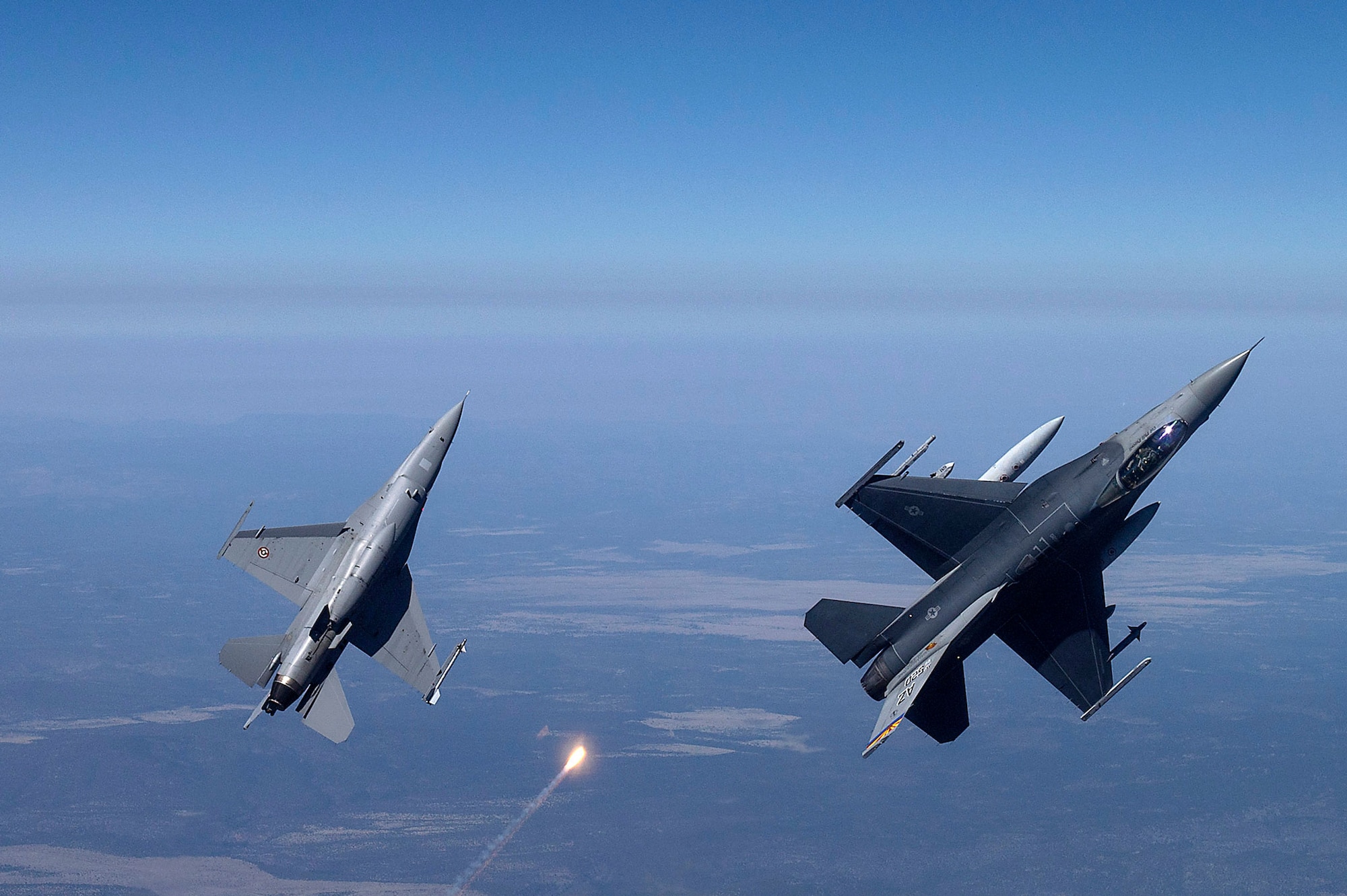 F-16s from the 162nd Wing, release flares while flying over a training range.