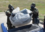 Senior Airman Jennifer Martinez and Senior Airman Ashley Garcia, 433rd Force Support Squadron, load a container onto a truck for transport during a field training exercise, April 10, 2021, at Joint Base San Antonio-Lackland, Texas. The exercise provided Reserve Citizen Airmen familiarity with real-world scenarios they could face in a deployed environment or at home. (U.S. Air Force photo by Tech. Sgt. Mike Lahrman)