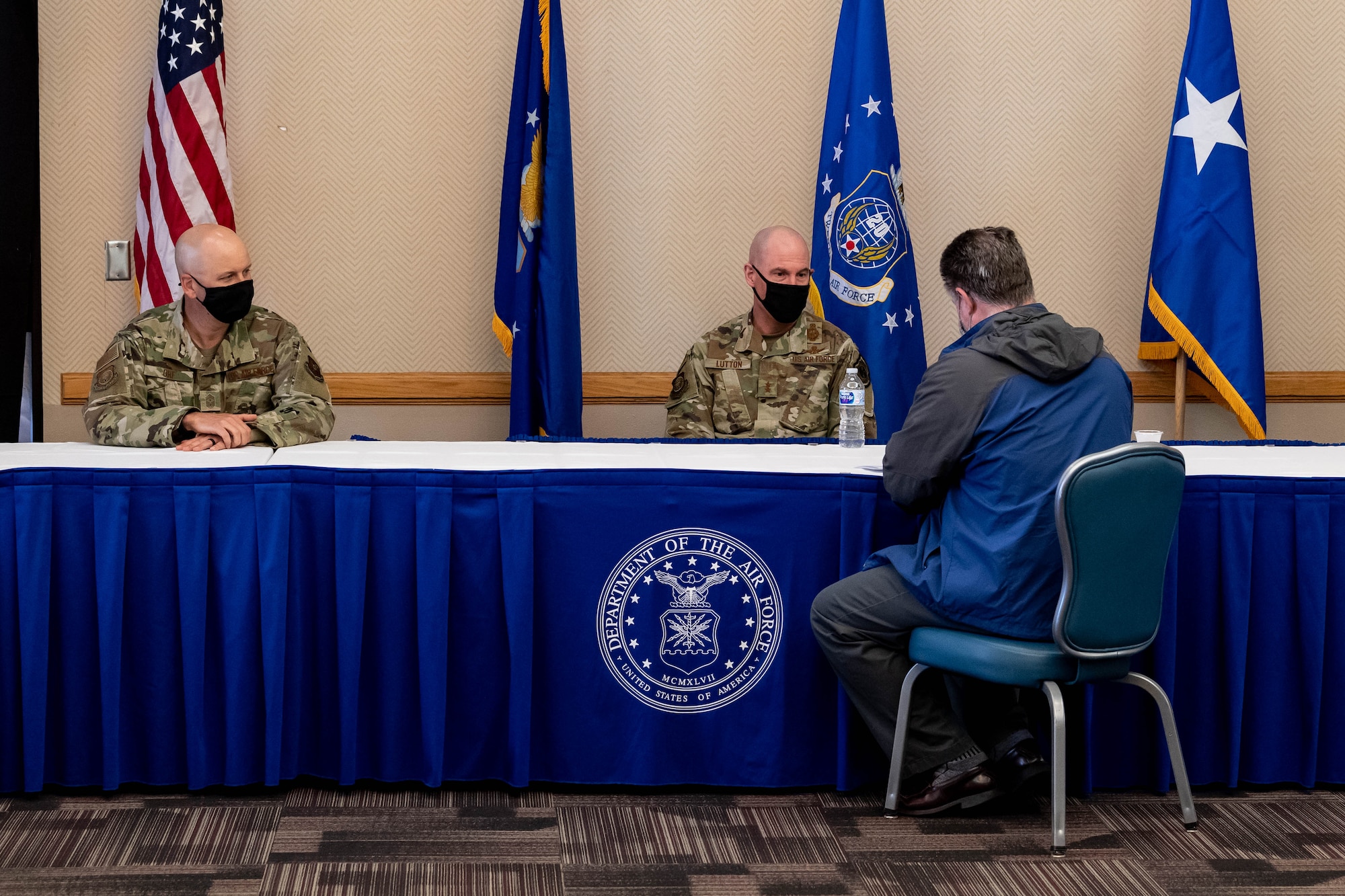 Two U.S. Air Force officers are interviewed while seated at a table.