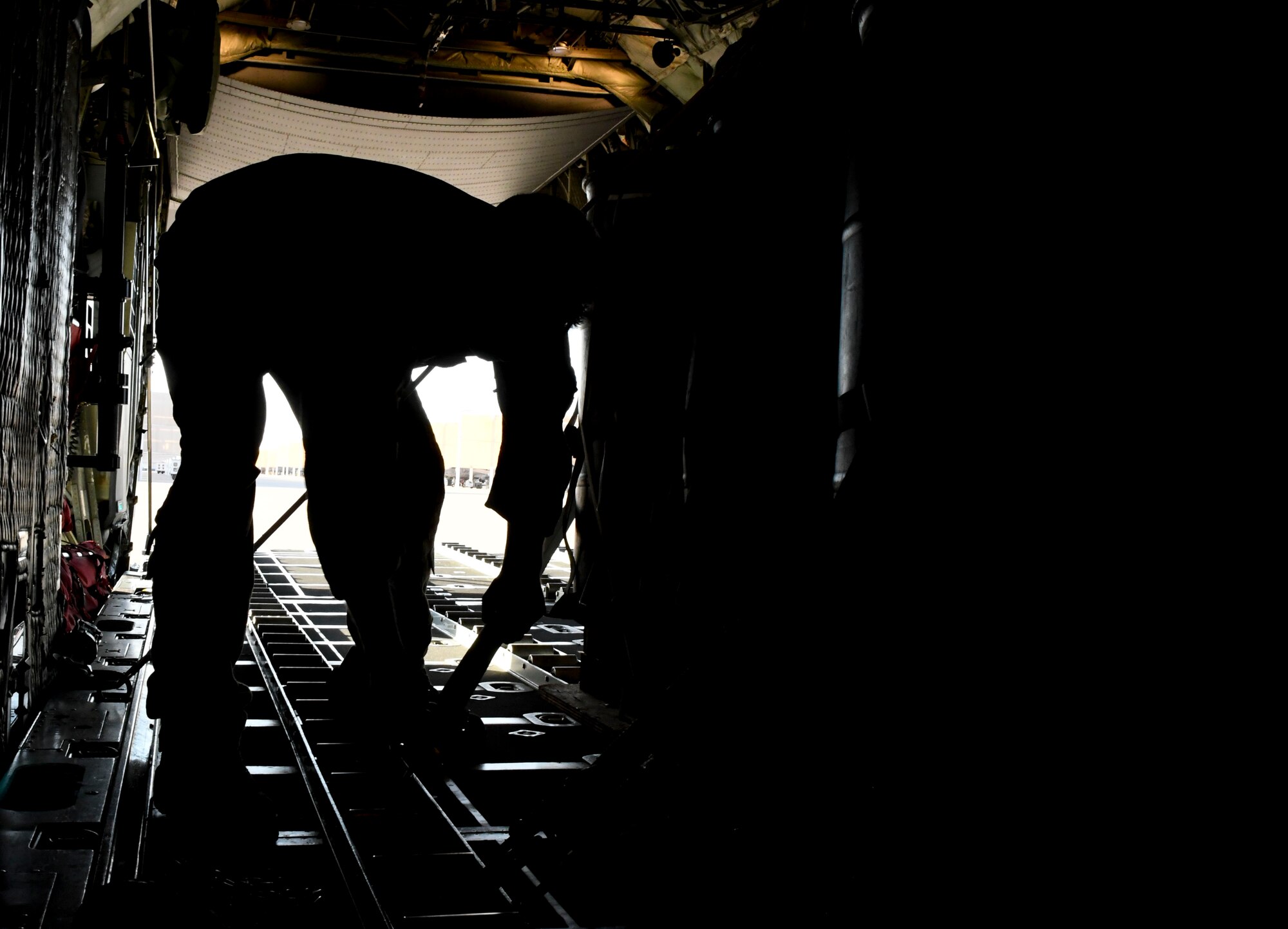 A photo of an airman securing equipment on an airplane