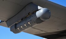 A photo of a targeting pod hanging from an aircraft