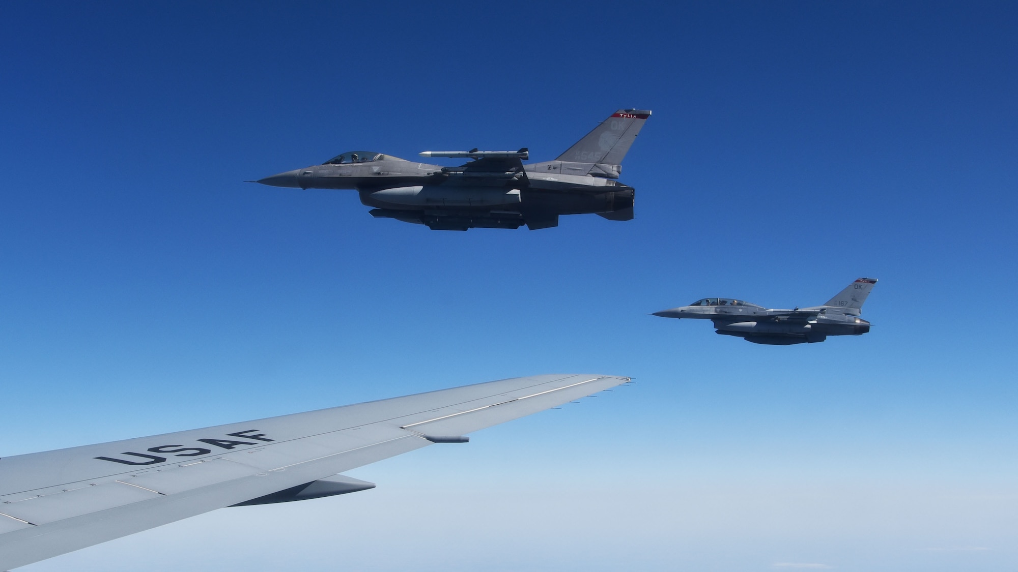Two F-16 Fighting Falcons from the 138th Fighter Wing, fly near the wing of a KC-46A Pegasus assigned to McConnell Air Force Base, Kan., April 10, 2021. The F-16s were two of eight being refueled by an aircrew from the 931st Air Refueling Wing. The F-16 is capable of traveling speeds up to 1,500 miles per hour, they can burn up to 8,000 pounds of fuel at low altitude.