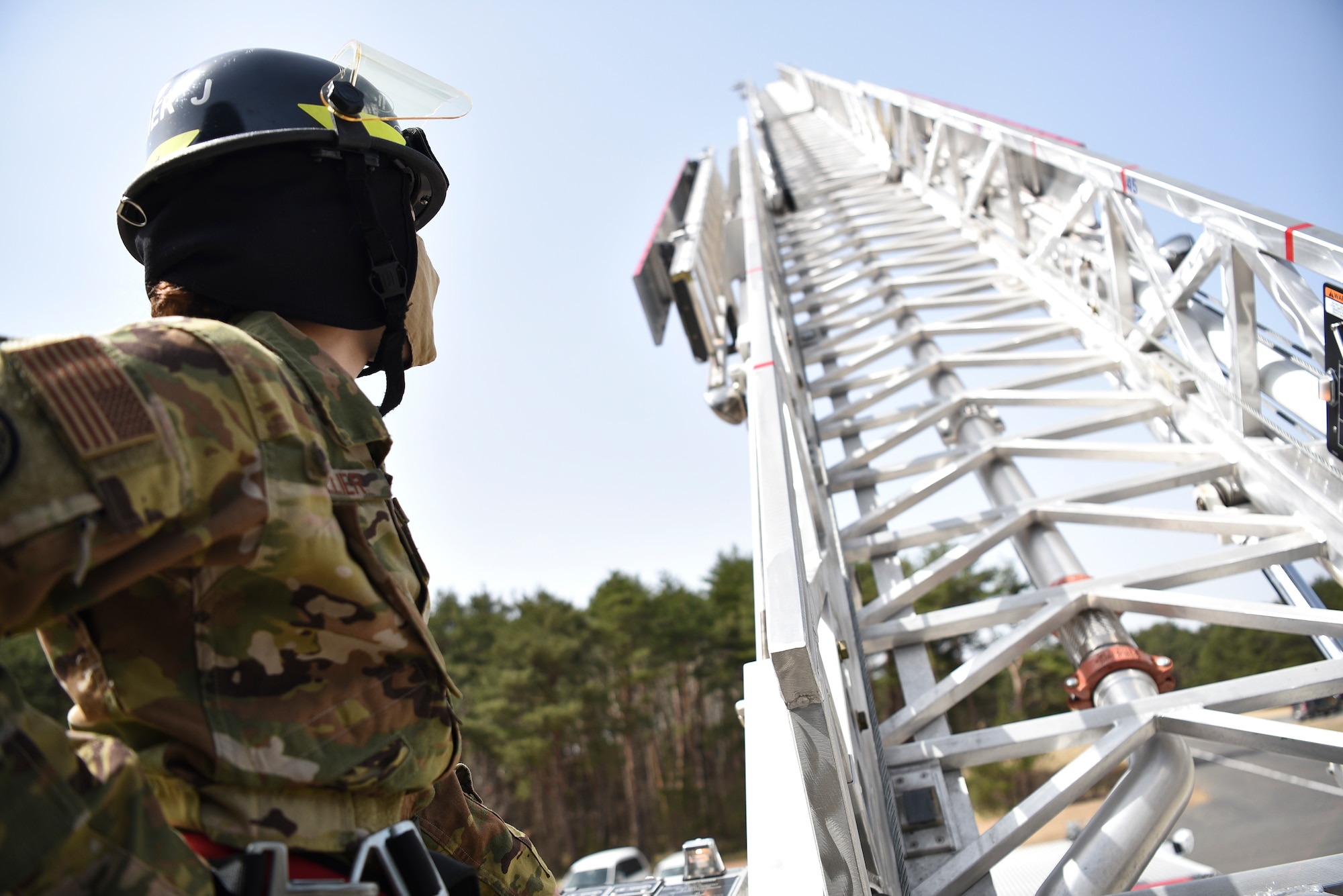 U.S. Air Force Staff Sgt. Journey Collier, a 35th Civil Engineer Squadron firefighter, raises a fire truck ladder at Misawa Air Base, Japan, March 31, 2021. Collier won the Air Force Military Firefighter of the Year award. This annual award recognizes a military firefighter for superior job performance and outstanding contributions to a Department of Defense and fire and emergency services organization. (U.S. Air Force photo by Airman 1st Class Joao Marcus Costa)