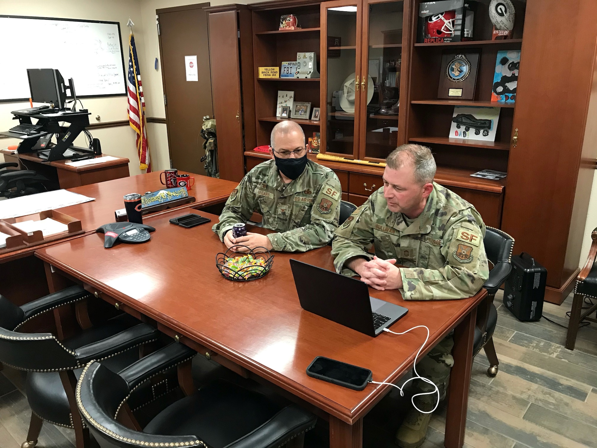 Two Airmen participate in a virtual meeting.
