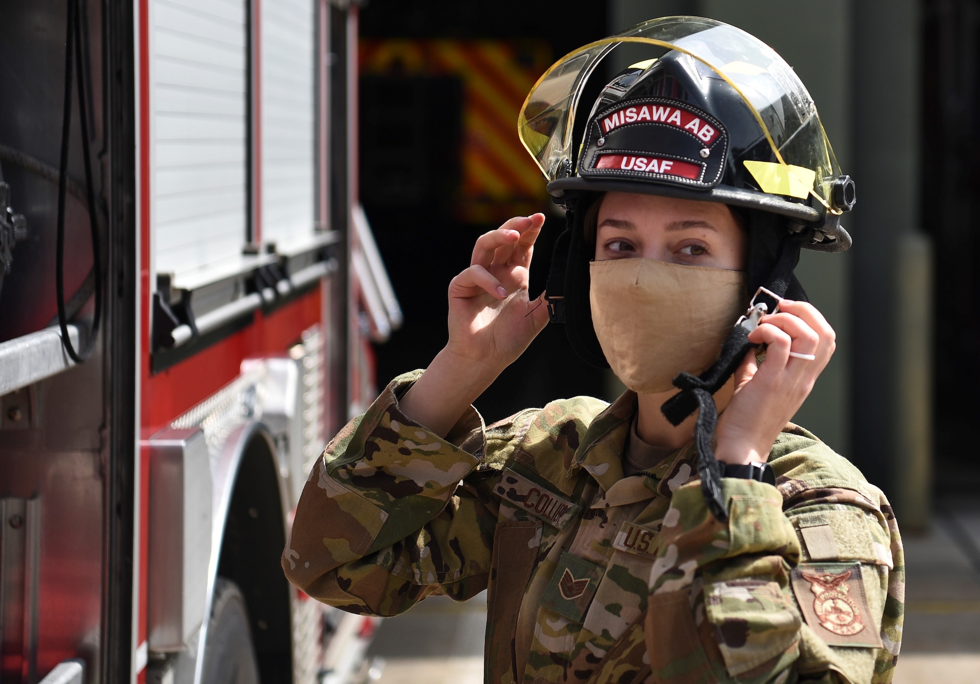U.S. Air Force Staff Sgt. Journey Collier, a 35th Civil Engineer Squadron firefighter, puts on her helmet at Misawa Air Base, Japan, March 31, 2021.  Collier recently won the Air Force Military Firefighter of the Year award. She also streamlined the certification process for new firefighters at Misawa. (U.S. Air Force photo by Airman 1st Class Joao Marcus Costa)