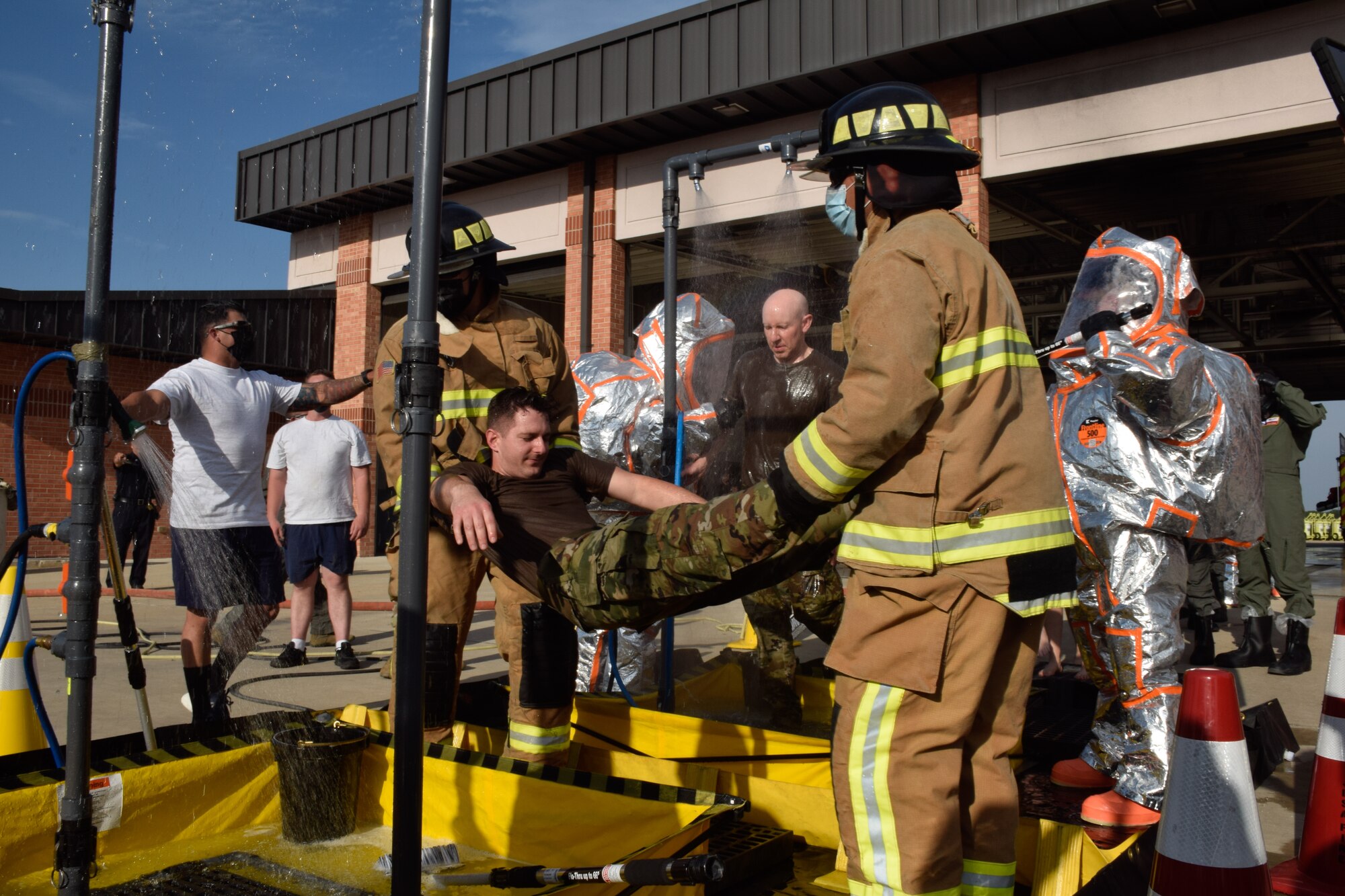 The 433rd Civil Engineer Squadron and Joint Base San Antonio Fire Department firefighters move a simulated contaminated patient during a joint training exercise at JBSA-Lackland, Texas, April 8, 2021. The firefighters trained to provide the appropriate care. (U.S. Air Force photo by Senior Airman Brittany Wich)