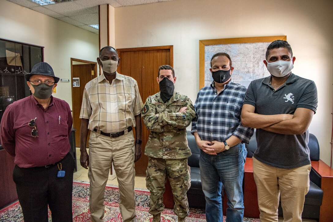an airmen poses with four other men in one straight line