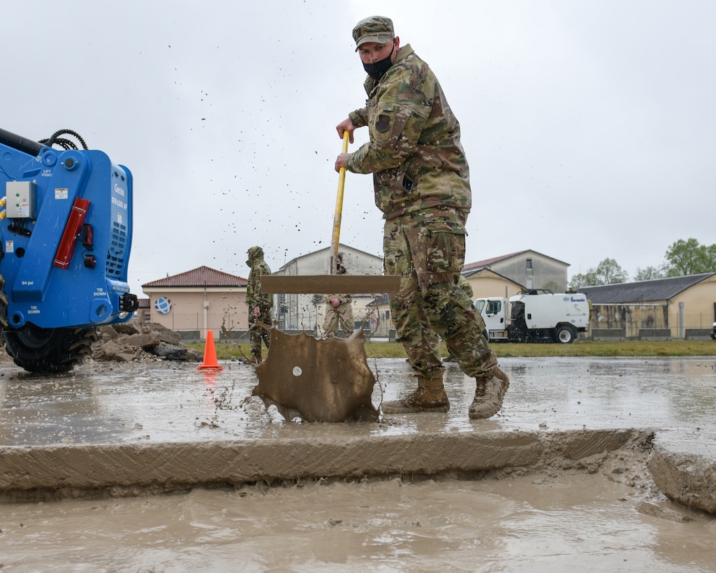 Senior Airman Joshua Carney, 31st Civil Engineer Squadron heavy equipment operator, mixes concrete during a base defense readiness exercise at Aviano Air Base, Italy, April 12, 2021. During the exercise, the 31st CES conducted Rapid Airfield Damage Repair (RADR) on the flightline and performed tasks such as upheaval marking, pavement cutting and excavation. (U.S. Air Force photo by Airman 1st Class Brooke Moeder)