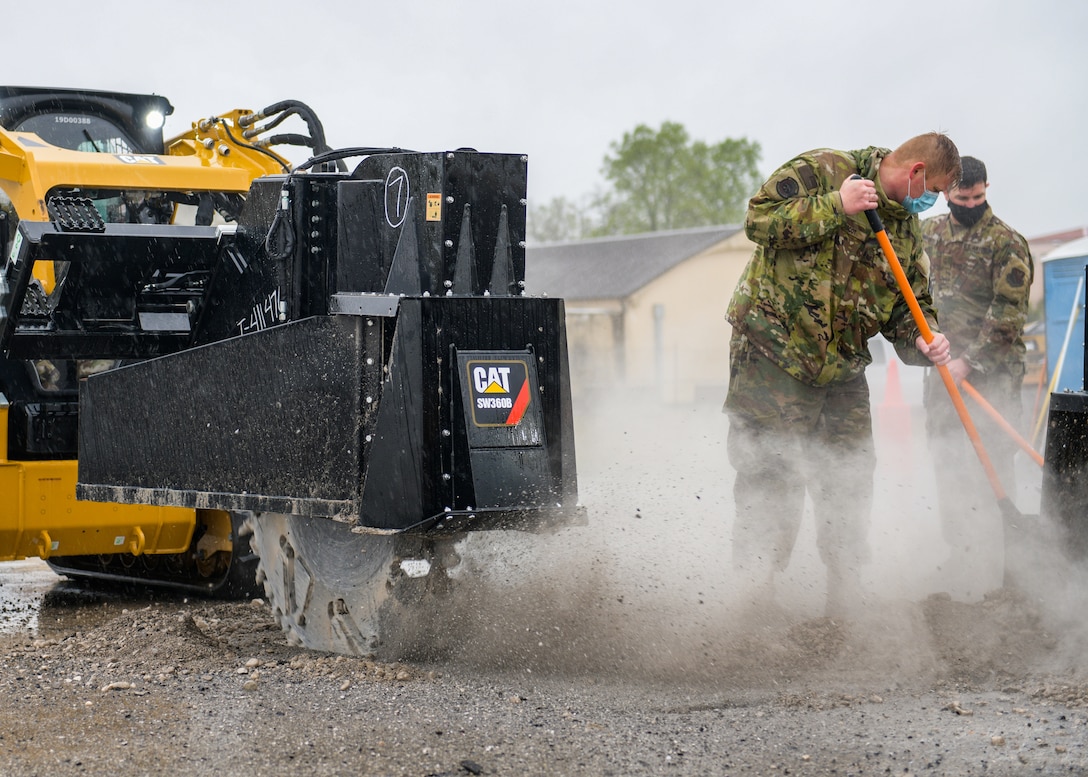 Tech. Sgt. Elliott Bercot, 31st Civil Engineer Squadron water and fuels system maintenance (WFSM) member, left, and Master Sgt. James Porter, 31st CES WFSM section chief, clear debris from a 60-inch wheel-saw during a base defense readiness exercise at Aviano Air Base, Italy, April 12, 2021. The 31st CES conducted Rapid Airfield Damage Repair (RADR) operations on the flightline and executed emergency operations center (EOC) events, fire protection, airfield damage assessment and more. (U.S. Air Force photo by Airman 1st Class Brooke Moeder)