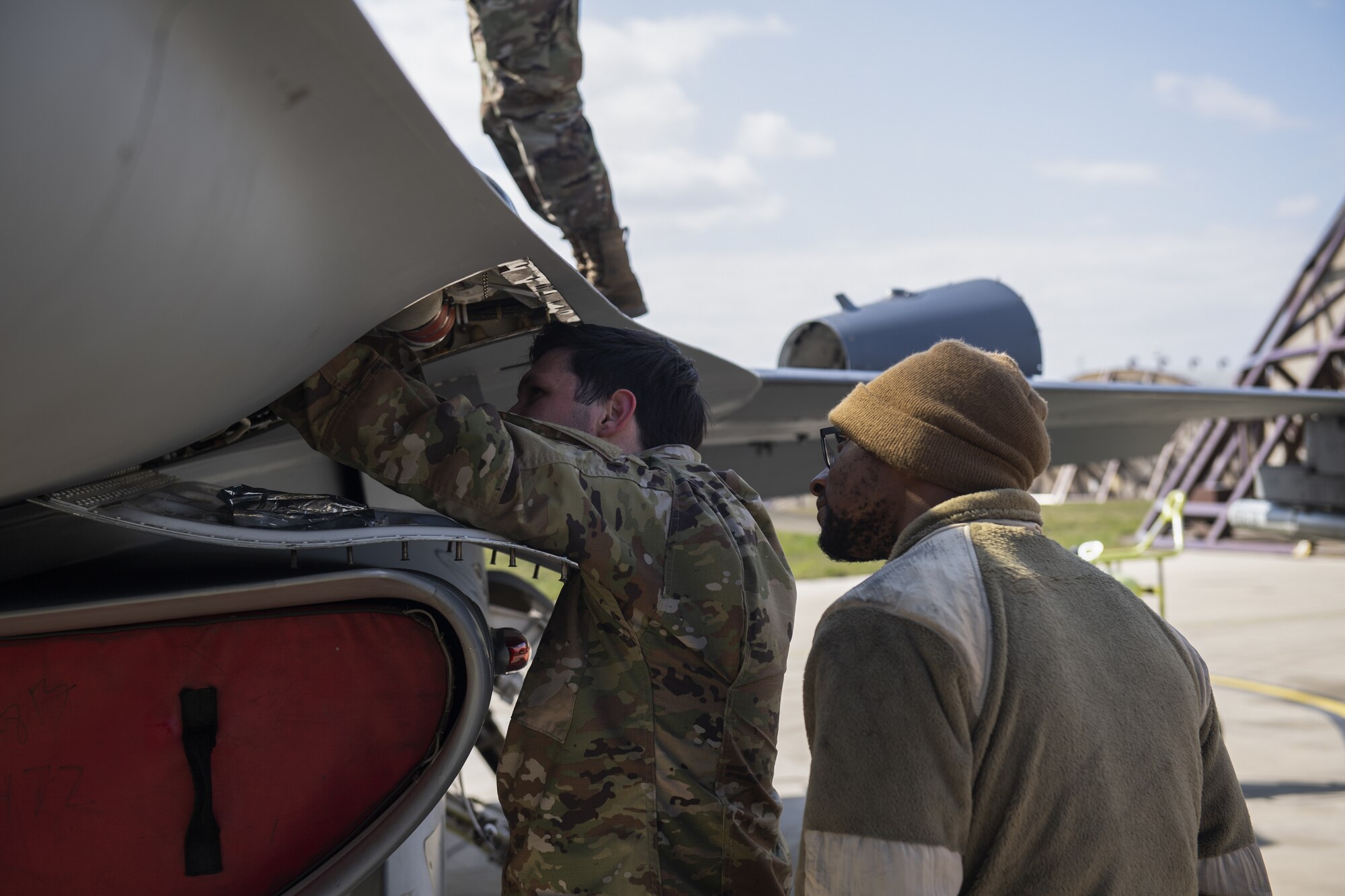 U.S Air Force Senior Airman Chase Peace, 52nd Aircraft Maintenance Squadron avionics specialist, left, and Senior Airman Tyler Logan, 52nd AMXS aerospace propulsion specialist, inspect the inside of a 480th Fighter Squadron F-16 Fighting Falcon before a flight for exercise Point Blank 21-02 at Spangdahlem Air Base, Germany, April 9, 2021. Pre-flight inspections are performed before each F-16 sortie and are one of the most important parts of a maintainer's duties. (U.S. Air Force photo by Senior Airman Ali Stewart)