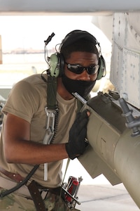 Senior Airman Maurice Starks and Staff Sgt. Omari Castleberry, both from the 127th Wiing, load a bomb unto a A-10 Thunderbolt II aircraft at Nellis Air Force Base, Nev., April 9, 2021.