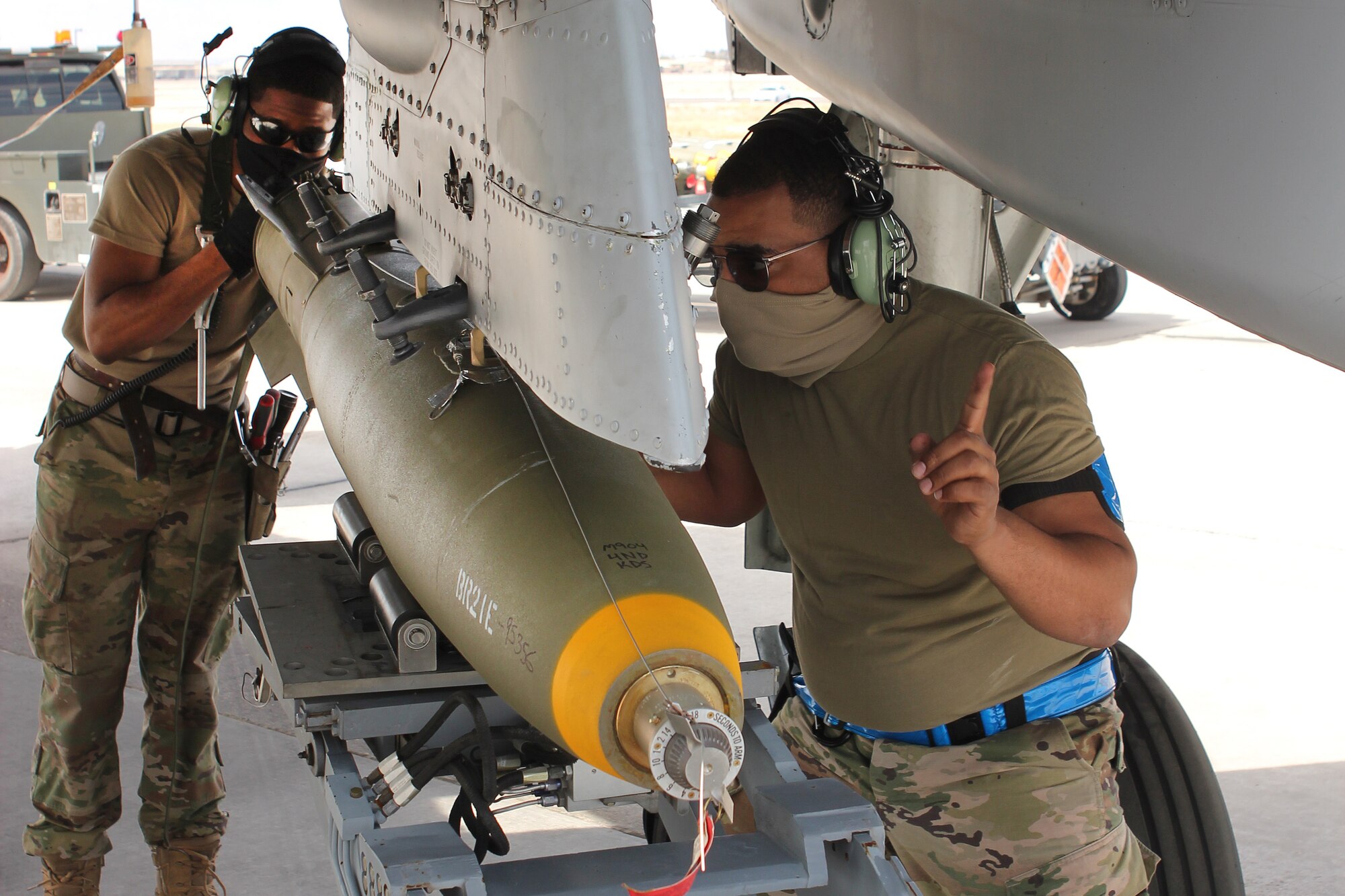 Senior Airman Maurice Starks and Staff Sgt. Omari Castleberry, both from the 127th Wiing, load a bomb unto a A-10 Thunderbolt II aircraft at Nellis Air Force Base, Nev., April 9, 2021.