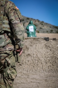 A soldier stands ready to fire pistol.
