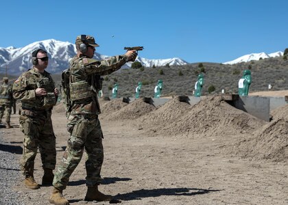 Soldier shooting pistol at range.
