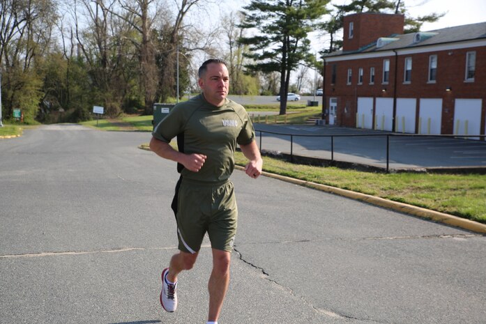 Gunnery Sgt. Evan Fancher, a project officer for Air and Amphibious Systems at Marine Corps Systems Command, demonstrates a prototype version of the new Physical Training Uniform. On April 13, MCSC awarded four contracts to manufacture prototypes for an updated PTU, which will then be tested and evaluated by MCSC. The uniform will provide a more athletic fit that aligns with today’s commercial clothing trends.