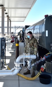 SELFRIDGE AIR NATIONAL GUARD BASE, Mich.-- Senior Airman Nick Bousquette, fuels distribution operator, 127th Fuels Management Flight based here, communicates via hand signals to a fellow fuels distribution operator while refueling an active duty C-5 Galaxy here on March 6, 2021.