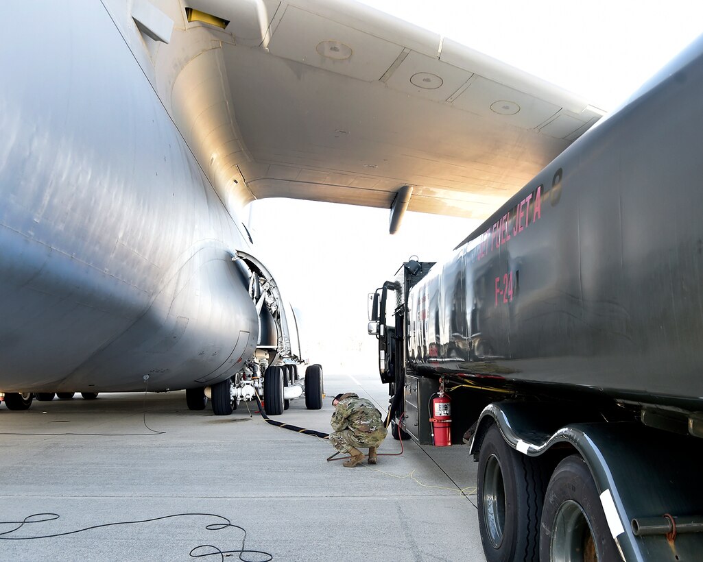 SELFRIDGE AIR NATIONAL GUARD BASE, Mich.-- Senior Airman Nick Bousquette, fuels distribution operator, 127th Fuels Management Flight based here, communicates via hand signals to a fellow fuels distribution operator while refueling an active duty C-5 Galaxy here on March 6, 2021.