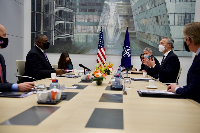 A man at a table gestures while speaking.