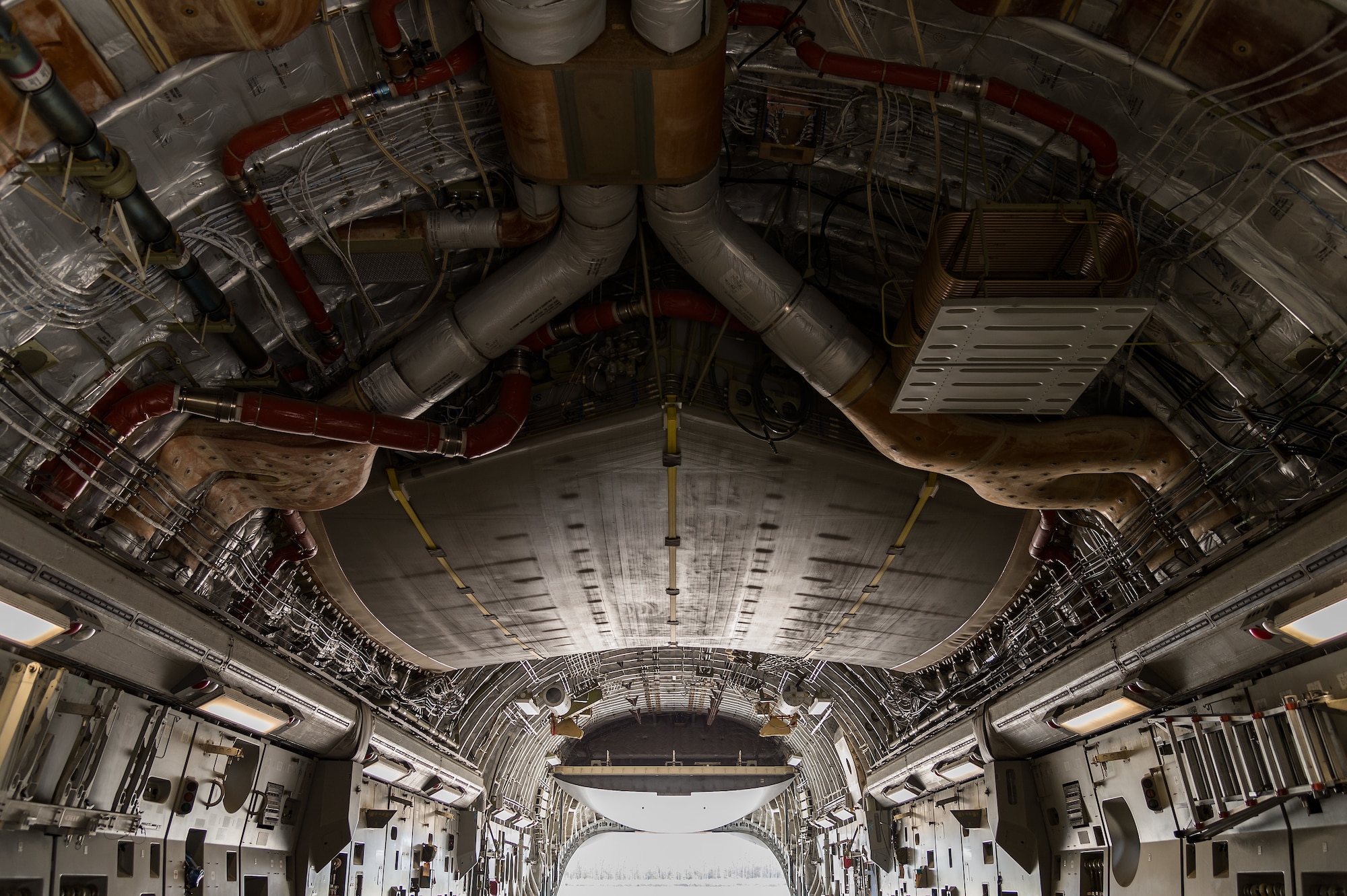 The upper interior cargo area of a C-17 Globemaster III is exposed as the aircraft waits for cargo to be loaded on Dover Air Force Base, Delaware, April 7, 2021. Cargo is loaded onto the C-17 through a large aft ramp and door system that accommodates virtually all of the Army’s air-transportable equipment such as a 69-ton M1 Abrams main battle tank, armored vehicles, trucks and trailers. (U.S. Air Force photo by Roland Balik)