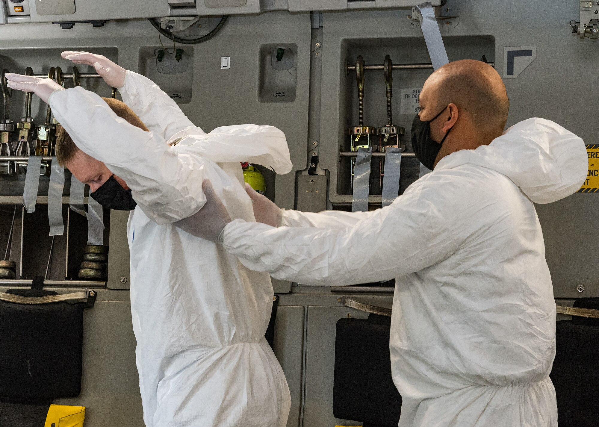 Master Sgt. Leonardo Erazo, 5th Health Care Operations Squadron medical logistics flight chief, checks the personal protective equipment of Staff Sgt. Beau Wilson, 5th HCOS biomedical equipment technician, on Dover Air Force Base, Delaware, April 7, 2021. Both are members of the 775th Expeditionary Aeromedical Evacuation Flight that participated in Negatively Pressurized Conex training on board a C-17 Globemaster III. (U.S. Air Force photo by Roland Balik)