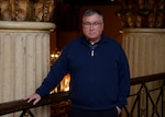 A man looks into the camera while standing in front of stone pillars inside the HDI Federal Center.