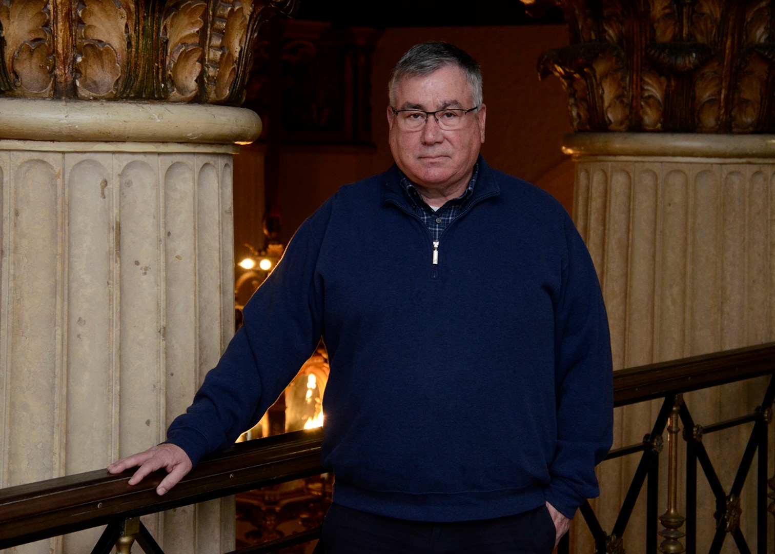 A man looks into the camera while standing in front of stone pillars inside the HDI Federal Center.