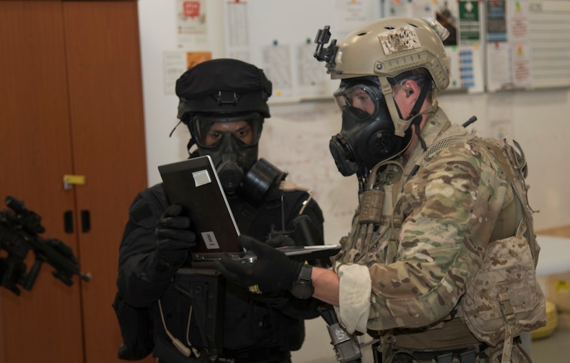 A U.S. Special Operations Forces members and a Qatari Special Forces soldier obtain a computer used in the creation of a crisis scenario during exercise Invincible Sentry, March 23, 2021, near Doha, Qatar. U.S. Central Command’s annual bilateral exercise enables the U.S. and Qatar to work together toward prevailing against complex regional security challenges. (U.S. Army photo by Staff Sgt. Daryl Bradford, Task Force Spartan Public Affairs)