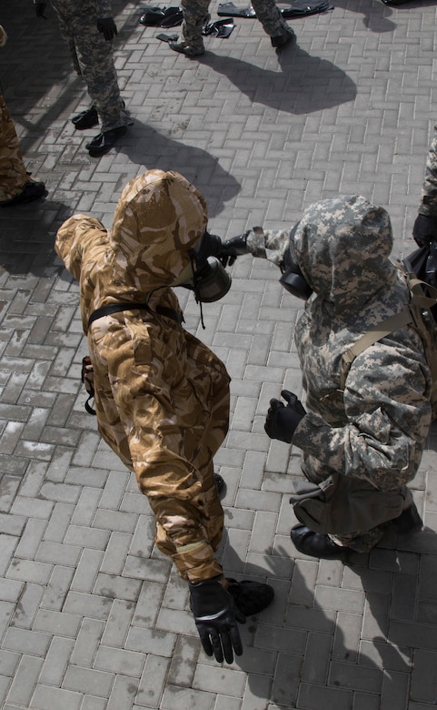 U.S. Army Soldiers from 318th Chemical Company, 1st Battalion, 35th Armored Regiment, 2nd Brigade, 1st Armored Division, Task Force Spartan, decontaminate a Qatari soldier in a simulated crisis scenario during Invincible Sentry, March 23, 2021, near Doha, Qatar. U.S. Central Command’s annual bilateral exercise allows the U.S. and Qatar to work together toward prevailing against complex regional security challenges. (U.S. Army photo by Staff Sgt. Daryl Bradford, Task Force Spartan Public Affairs)