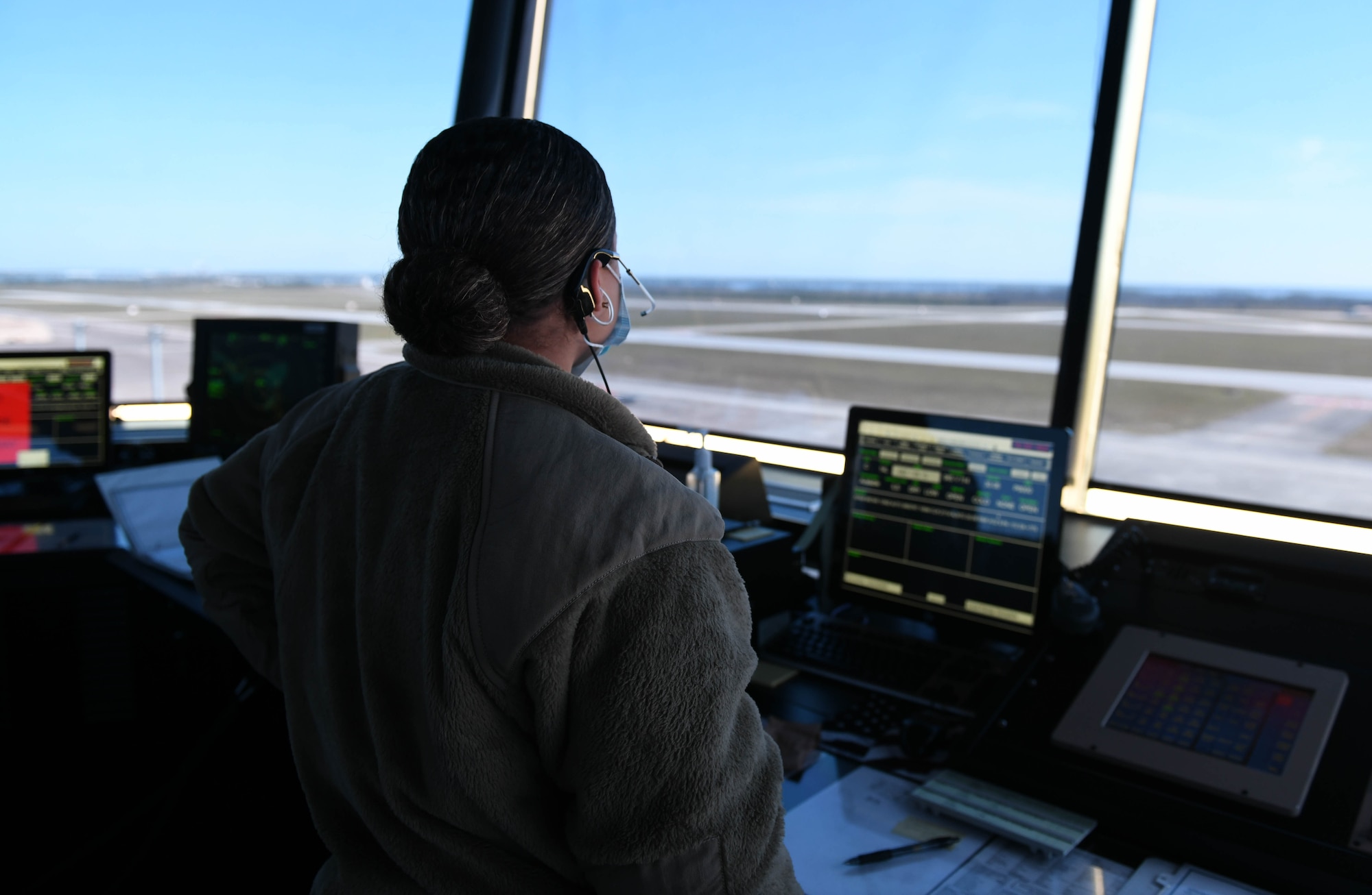 An Airman looks at the flightline from the air traffic control tower.