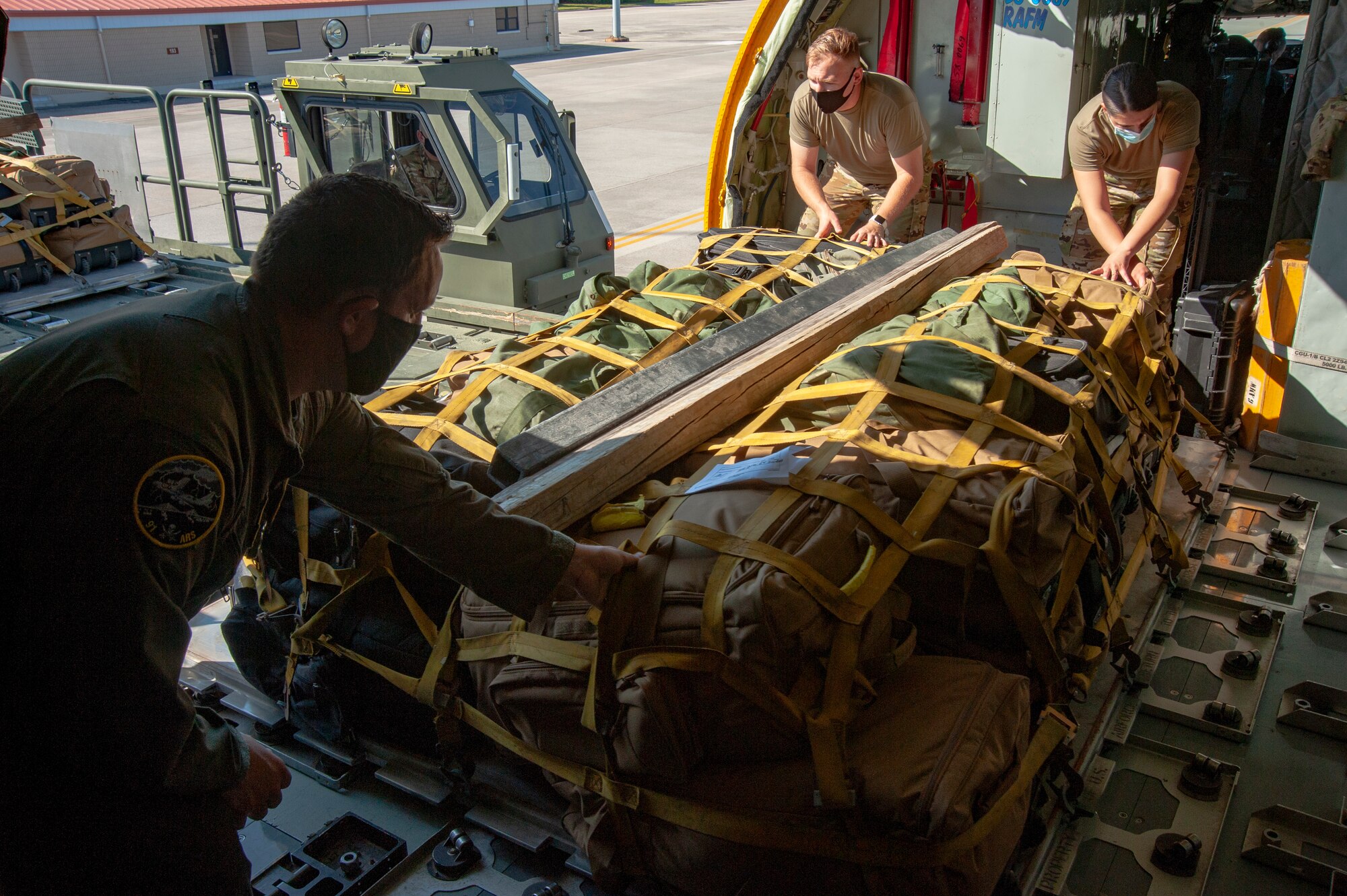 Airmen from the 91st Air Refueling Squadron roll cargo for a deployment onto a KC-135 Stratotanker aircraft, April 9, 2021, at MacDill Air Force Base, Fla. The cargo is loading and then secured on rollers, making it easy to offload when arriving at Al Udeid Air Base, Qatar. (U.S. Air Force photo by Airman 1st Class David D. McLoney)