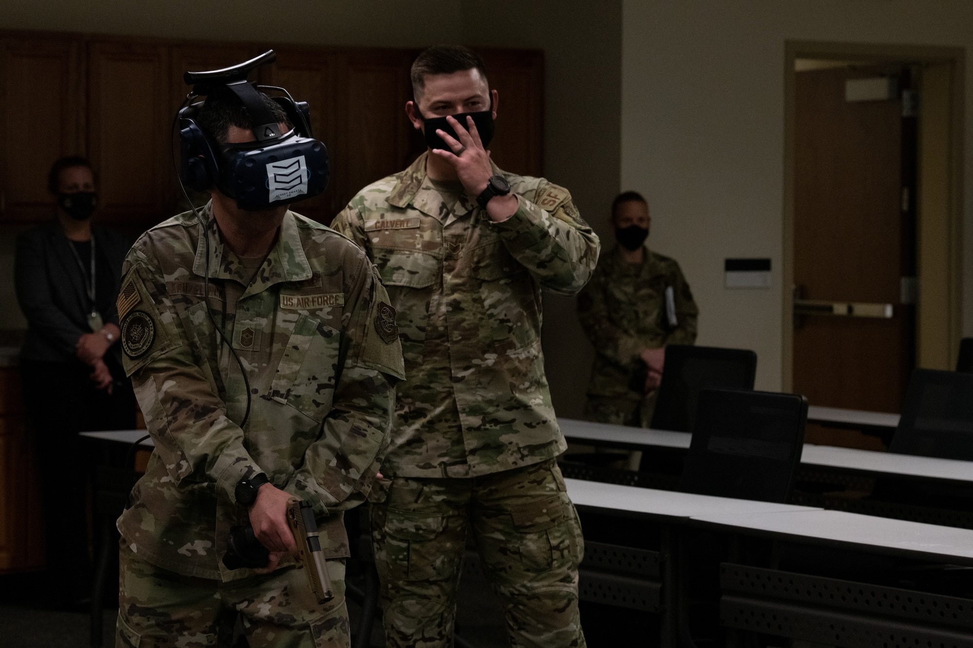Man wearing virtual reality headset holds weapon
