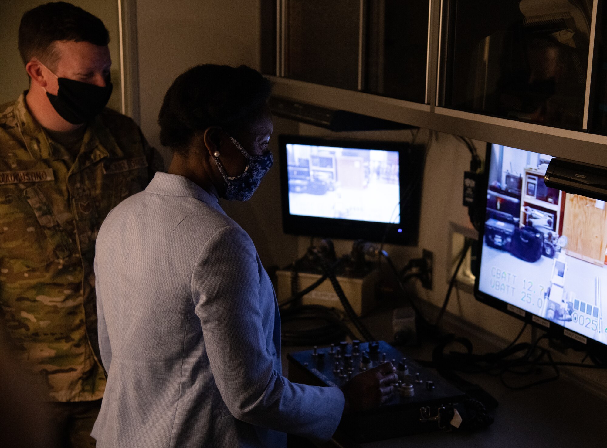 Woman uses controls in front of a computer screen