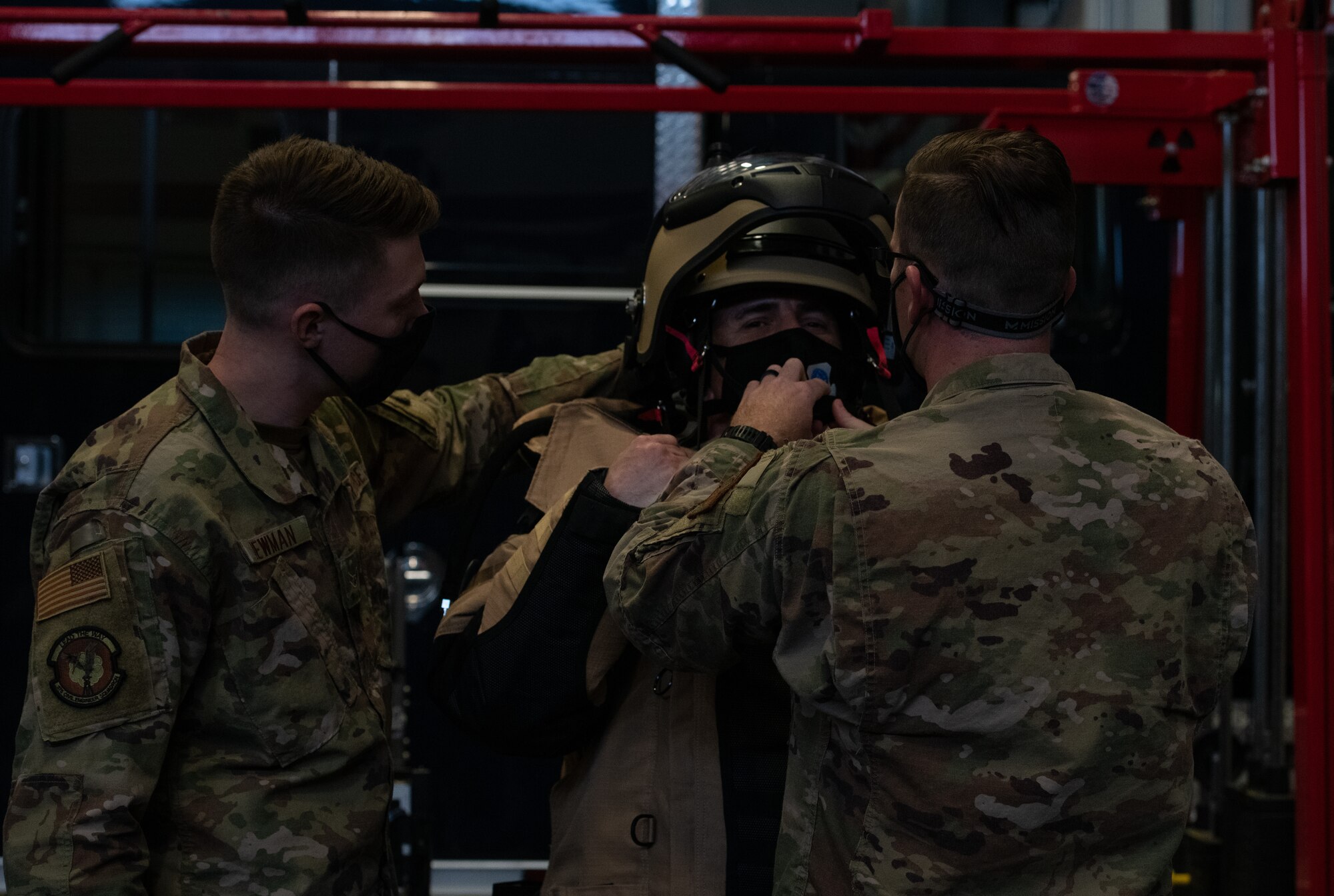 Man puts on bomb suit with assistance of others