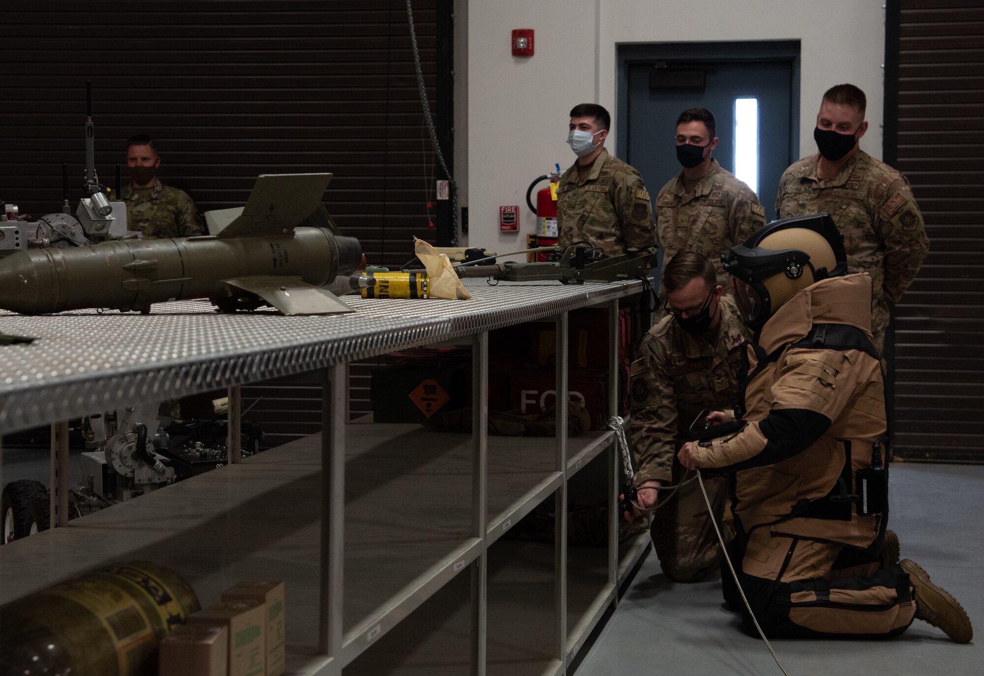 Man in bomb suit kneels