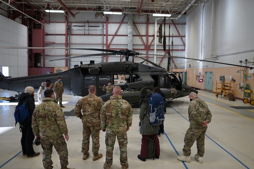 Members of the Alaska National Guard, along with members of the Alaska Department of Environmental Conservation, receive a passenger safety briefing prior to boarding an Army National Guard UH-60 Blackhawk for a flight from Bethel to Tuluksak, Alaska, April 8, 2021. Members of the Alaska Department of Military and Veterans Affairs, the Department of Environmental Conservation, and the Department of Commerce, Community, and Economic Development traveled to Western Alaska April 7-9 to meet with Tribal leaders and citizens in Bethel, Tuluksak, and Chevak to discuss disaster assistance measures and processes in light of recent emergencies that have occurred in the region, and in preparation for the upcoming flood season. (U.S. Army National Guard photo by Dana Rosso)