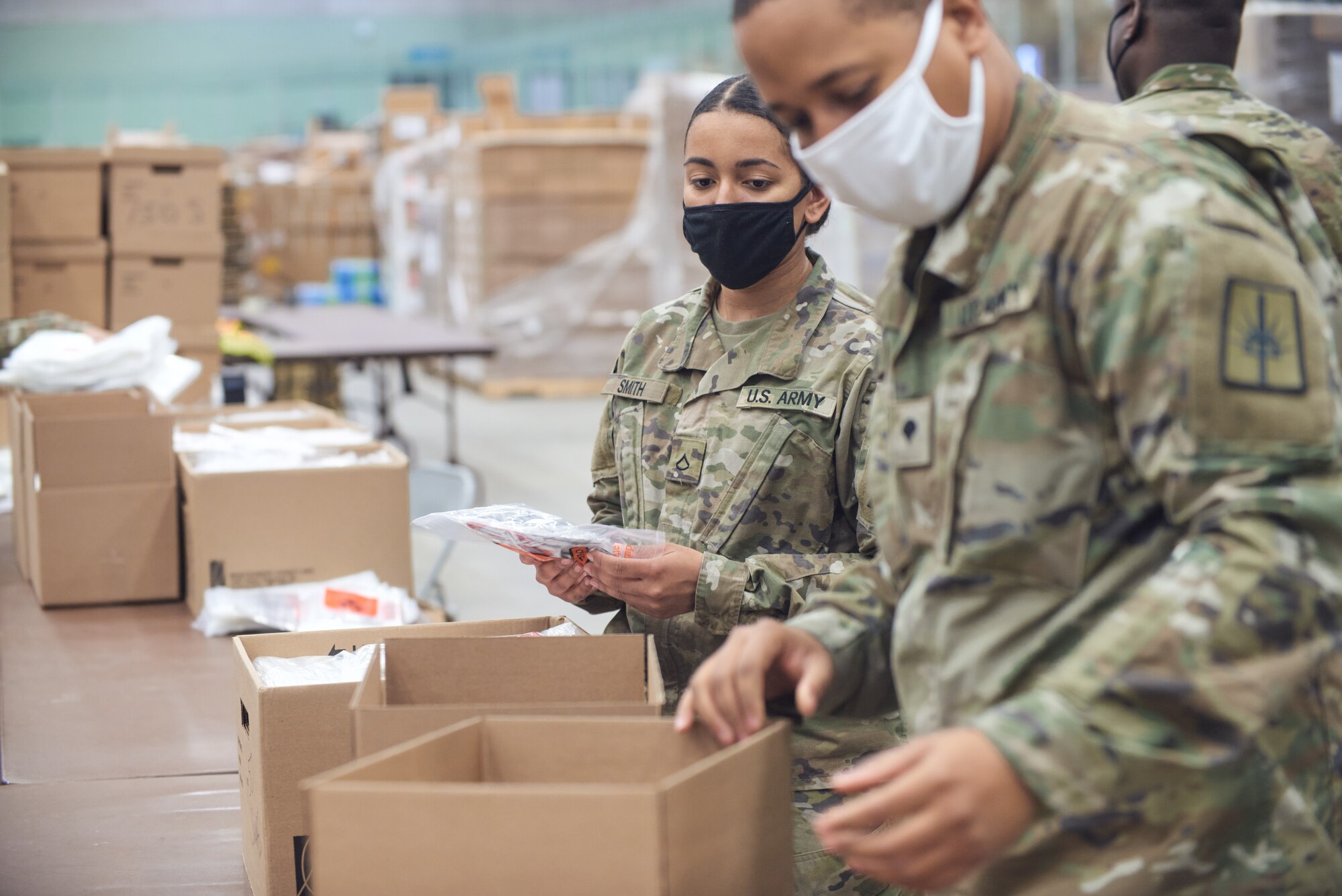 Army Pfc. Sydney Smith, with the 206th Military Police Company, and Spc. Claude Hamilton, a construction engineer assigned to the 1156th Engineer Company, assemble COVID-19 test kits to be shipped across New York state, at Hudson Valley Community College in Troy April 13, 2021. The Guard has helped assemble and ship 10 million test kits since last April.